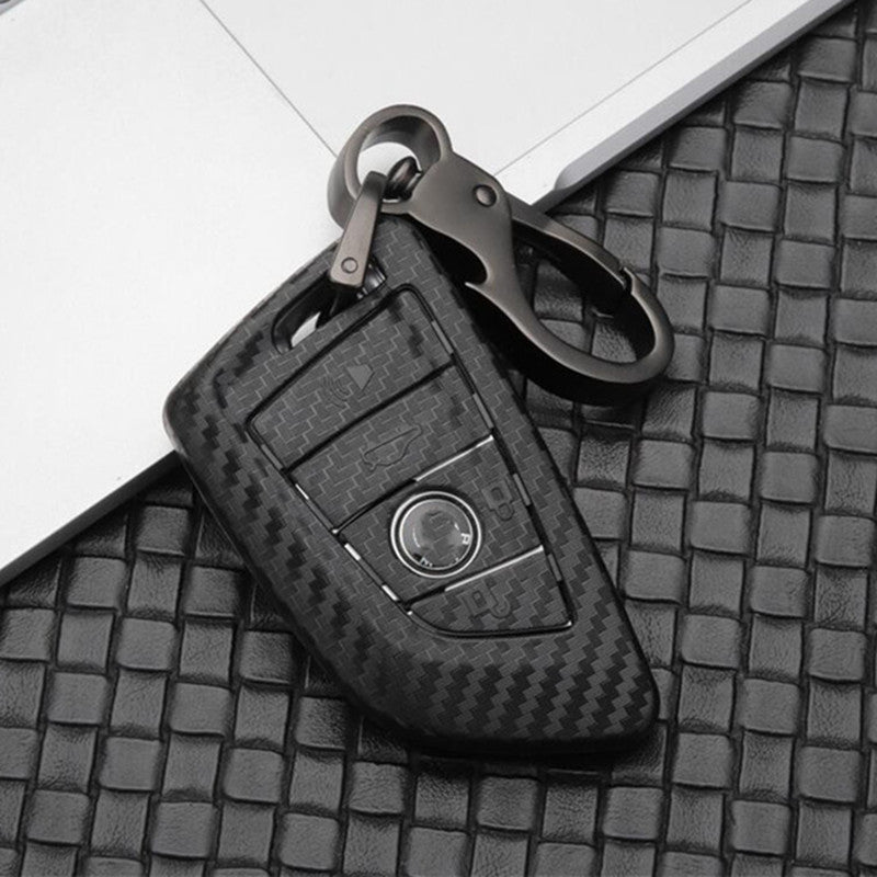 Replacement 4-button smart key case for BMW – carbon fibre case with keyring on a woven leather surface