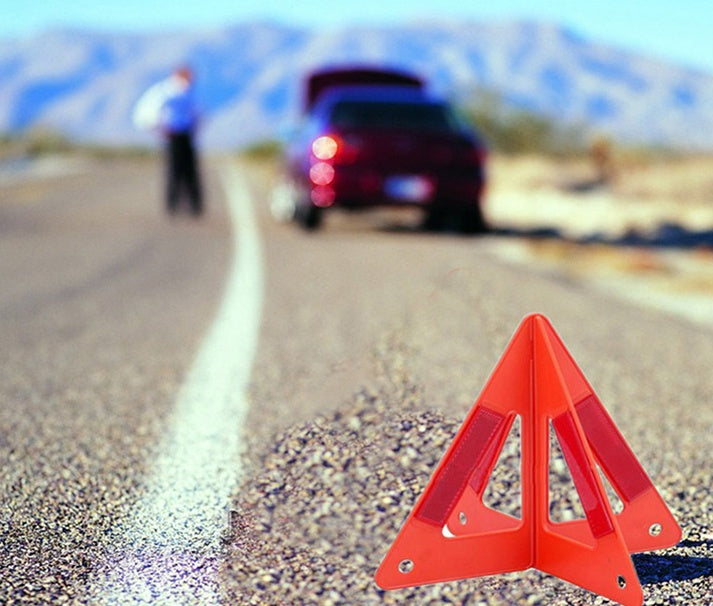 Warning triangle – foldable, reflective – placed on a road behind a parked car