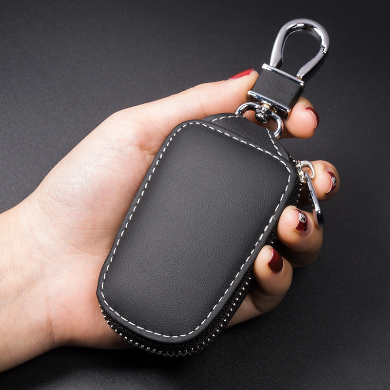 Cowhide leather zip cover for smart car keys – black pouch held in a hand showing size