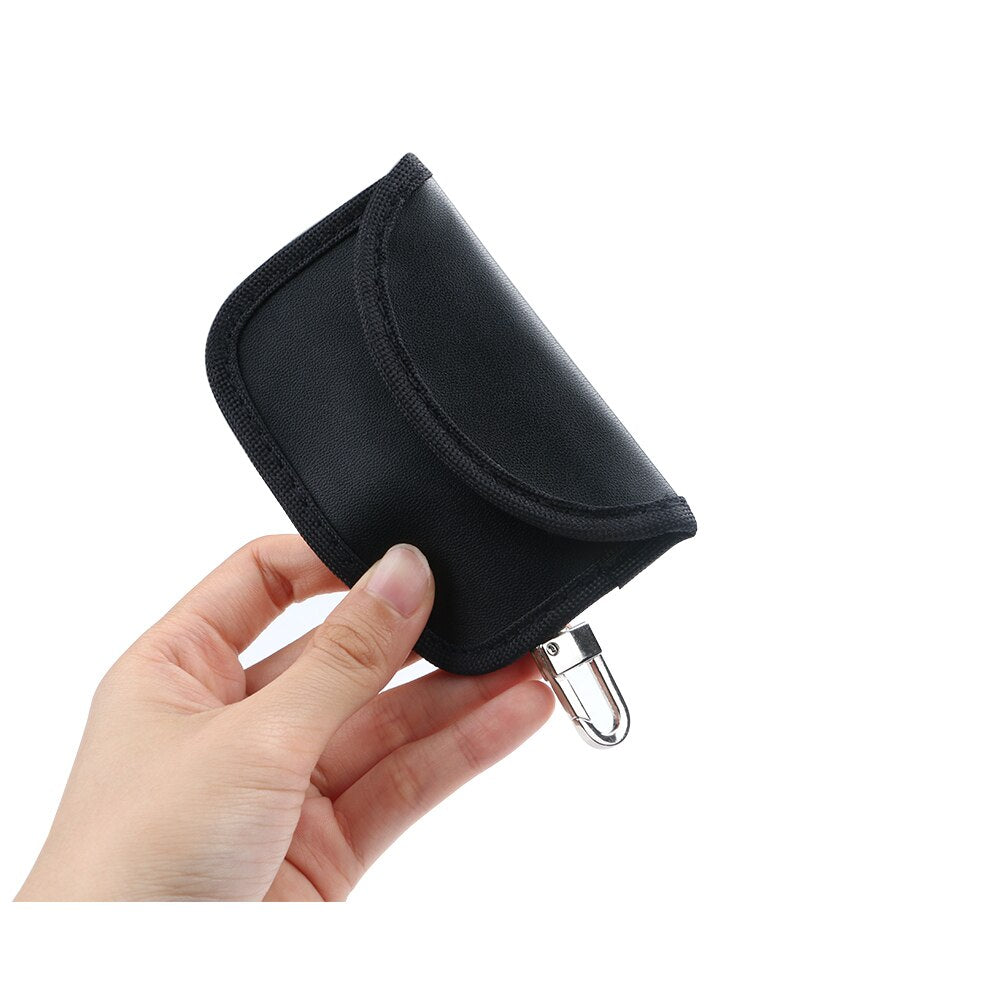 Black PU car key case with anti-scan protection – held in hand showing front flap closed