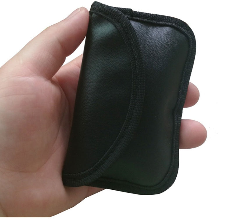 Black PU car key case with anti-scan protection – held in hand showing side profile
