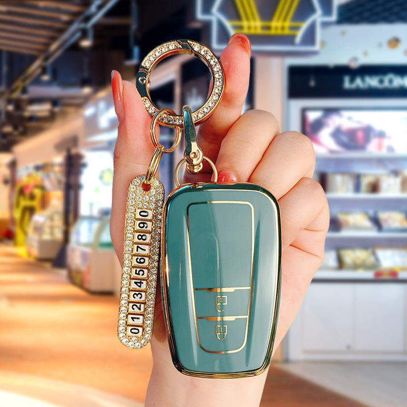 Key fob cover for Toyota 2-button keys – TPU – sage green cover held in hand with crystal keyring and number plate charm