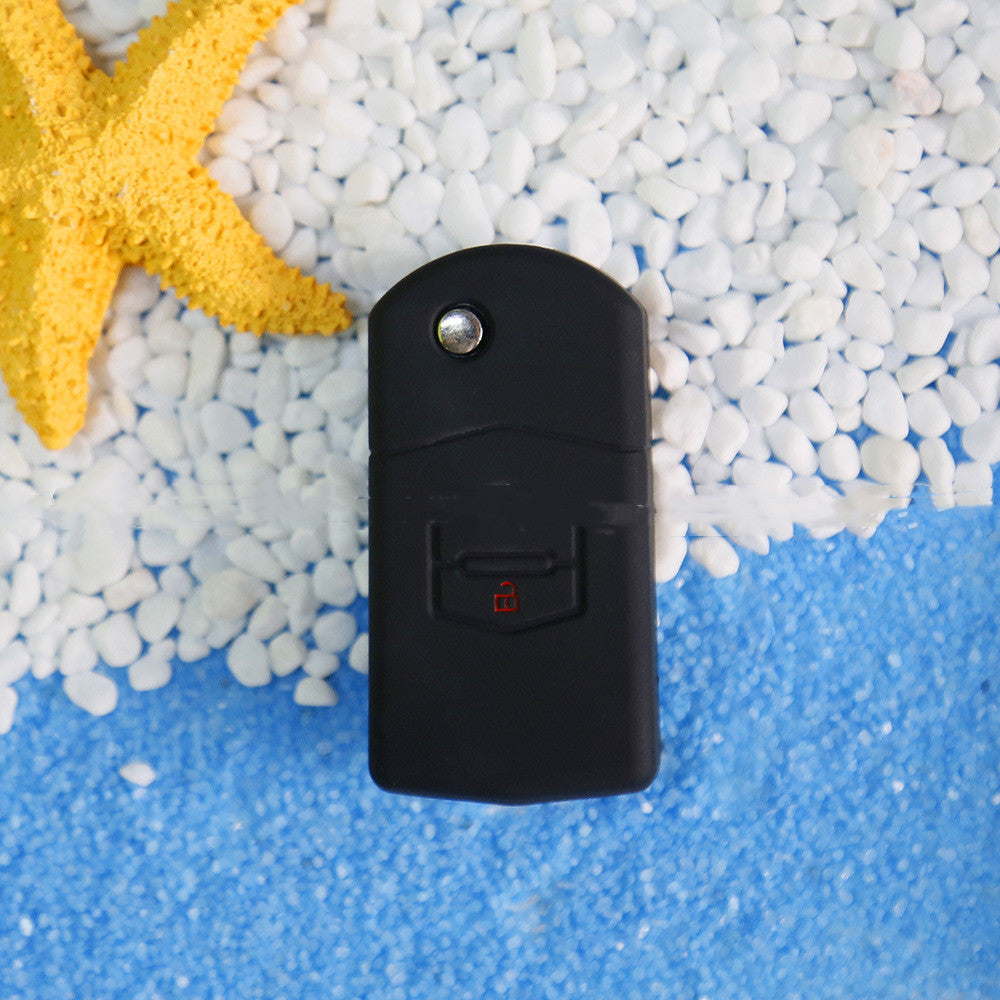 Key fob cover for Mazda 2-button folding keys – silicone – side view showing the unlock button on pebbles